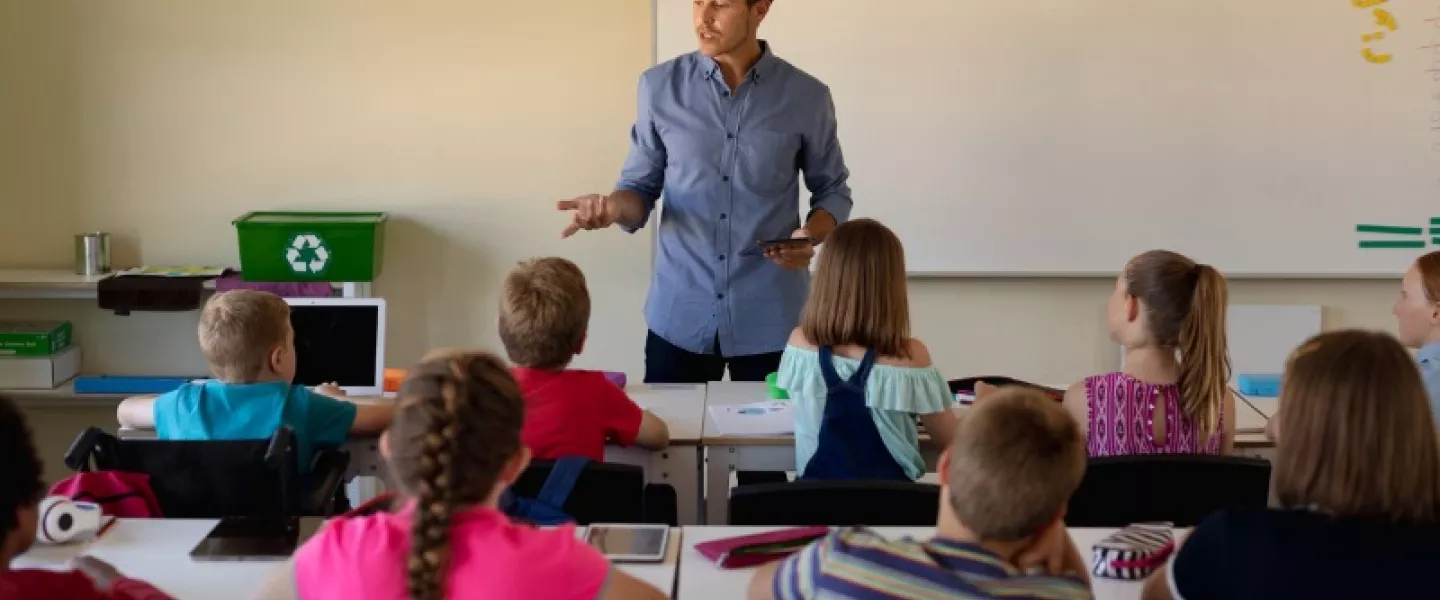 male-school-teacher-standing-in-an-elementary-school.jpg